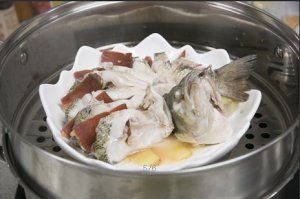 將鱸魚成花狀擺好，將火腿切片放入各縫隙中，放入鍋中隔水蒸12分鐘拿出，撒上蔥花即可。