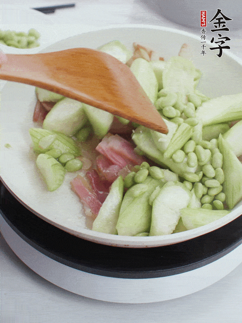 依次下絲瓜、青豆翻炒，炒至絲瓜打蔫縮小。