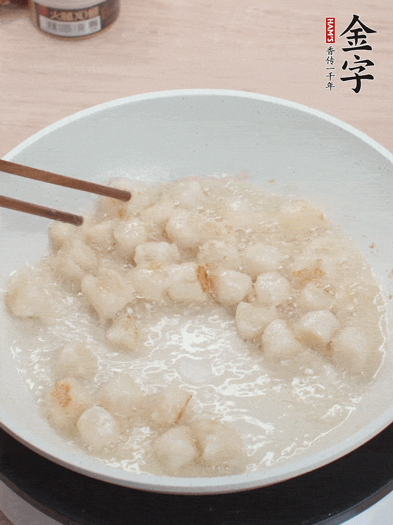 油溫4成熱，鮮貝蘸干淀粉下鍋煎，一面微黃后翻面。