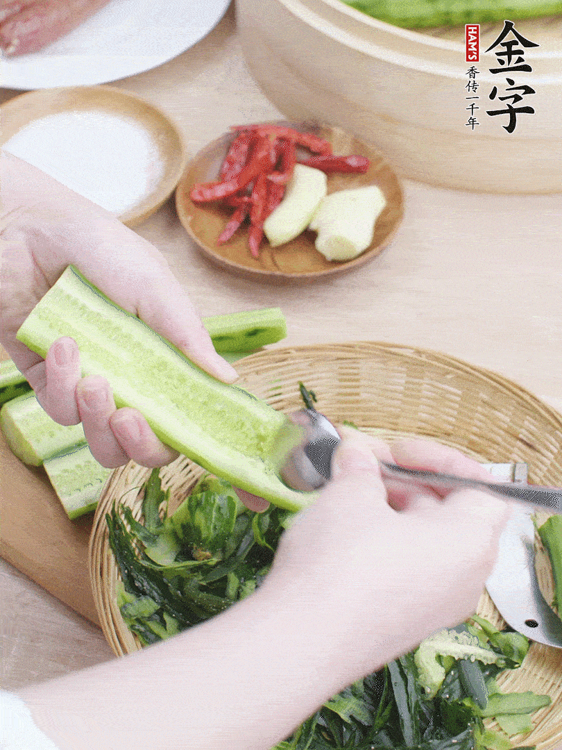 黃瓜削皮，對(duì)半切開，勺子挖去內(nèi)瓤，斜刀切片。青蒜斜刀切段。