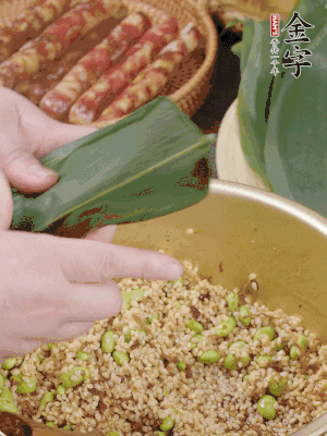粽葉往下折，完全蓋住，兩側捏緊。