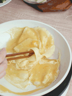 油6成熱時(shí)，下雞蛋液，邊緣凝固時(shí)翻拌成塊狀。