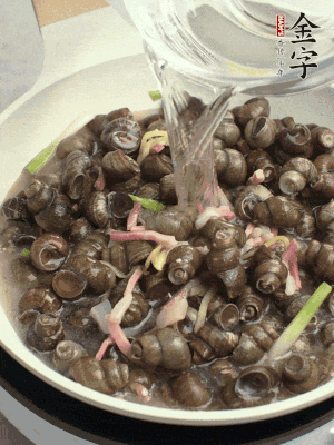 倒處理干凈的螺螄翻炒，加3勺料酒。加清水蓋過螺螄，中火蓋蓋煮5分鐘。