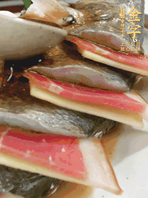 魚肚中塞蔥結、火腿片，魚身上碼放姜片、火腿片，倒入混合的料汁。