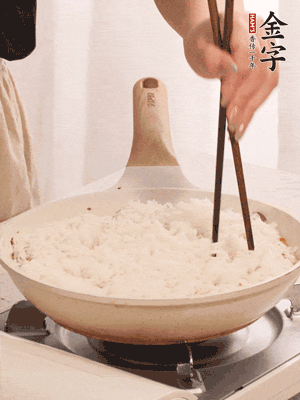 把瀝干水分的米飯均勻鋪在上面，筷子戳幾個洞，以便透氣，轉(zhuǎn)小火蓋上蓋子燜至水分收干，大概10分鐘。
